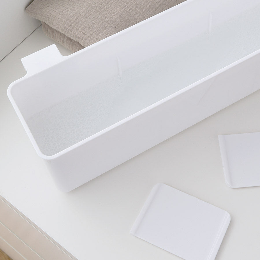 Weißer Wickeltisch Organizer aus Kunststoff mit Wasser gefüllt.