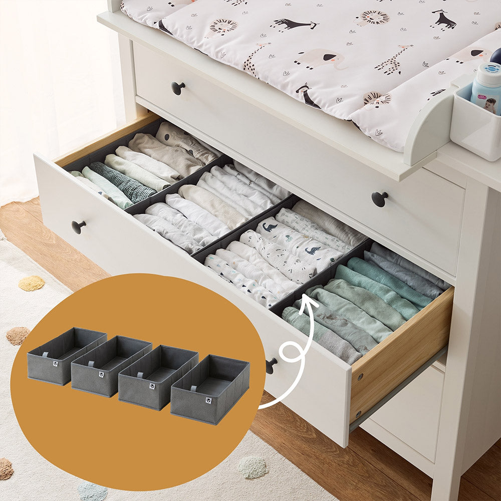 Weiße IKEA Hemnes Kommode, die als Wickelkommode genutzt wird. In den Schubladen sind mit Babykleidung gefüllte Schubladen Organizer.