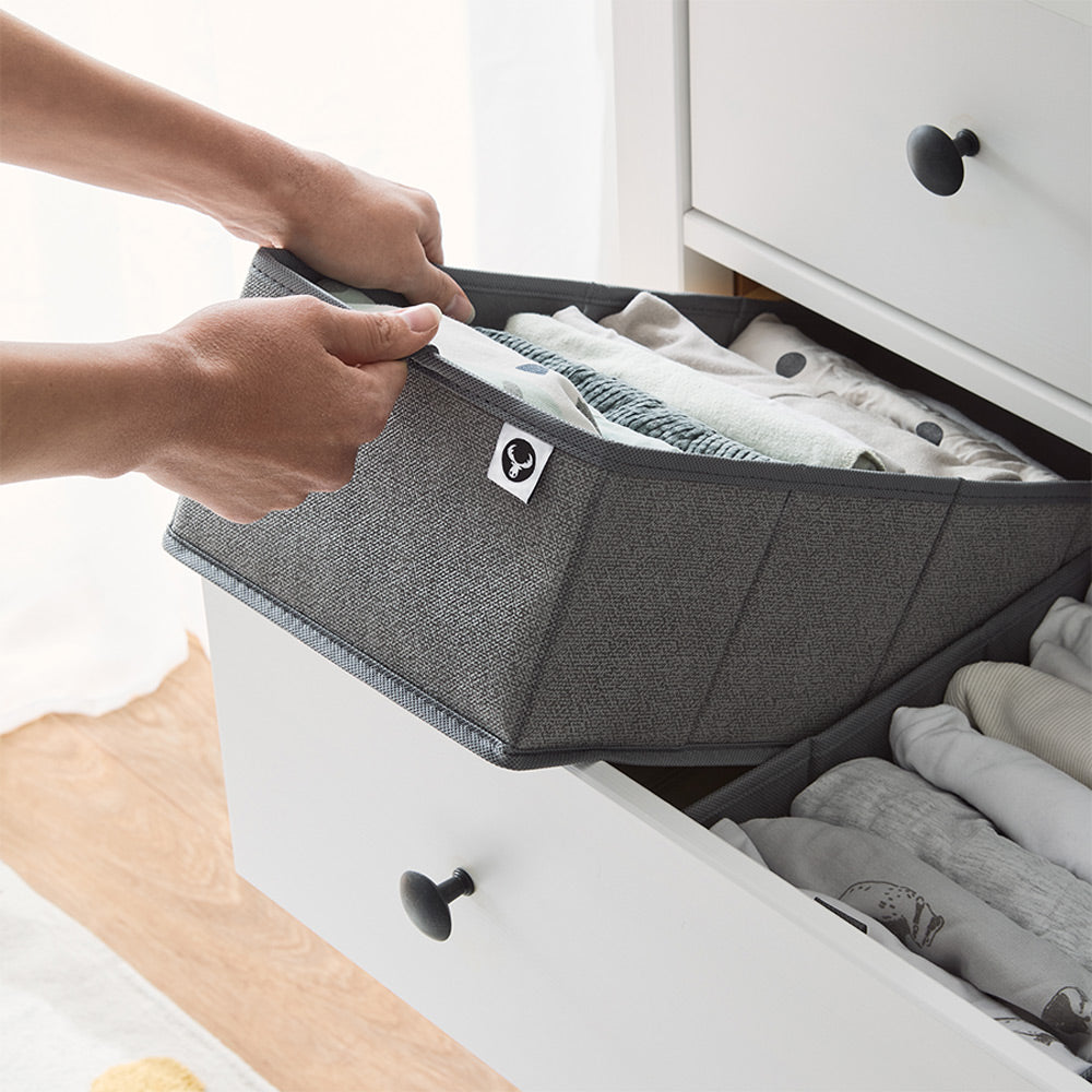 Eine weiße IKEA Hemnes Kommode, die mit Schubladen Organizern bestückt wurde. Diese sind mit Babykleidung gefüllt.
