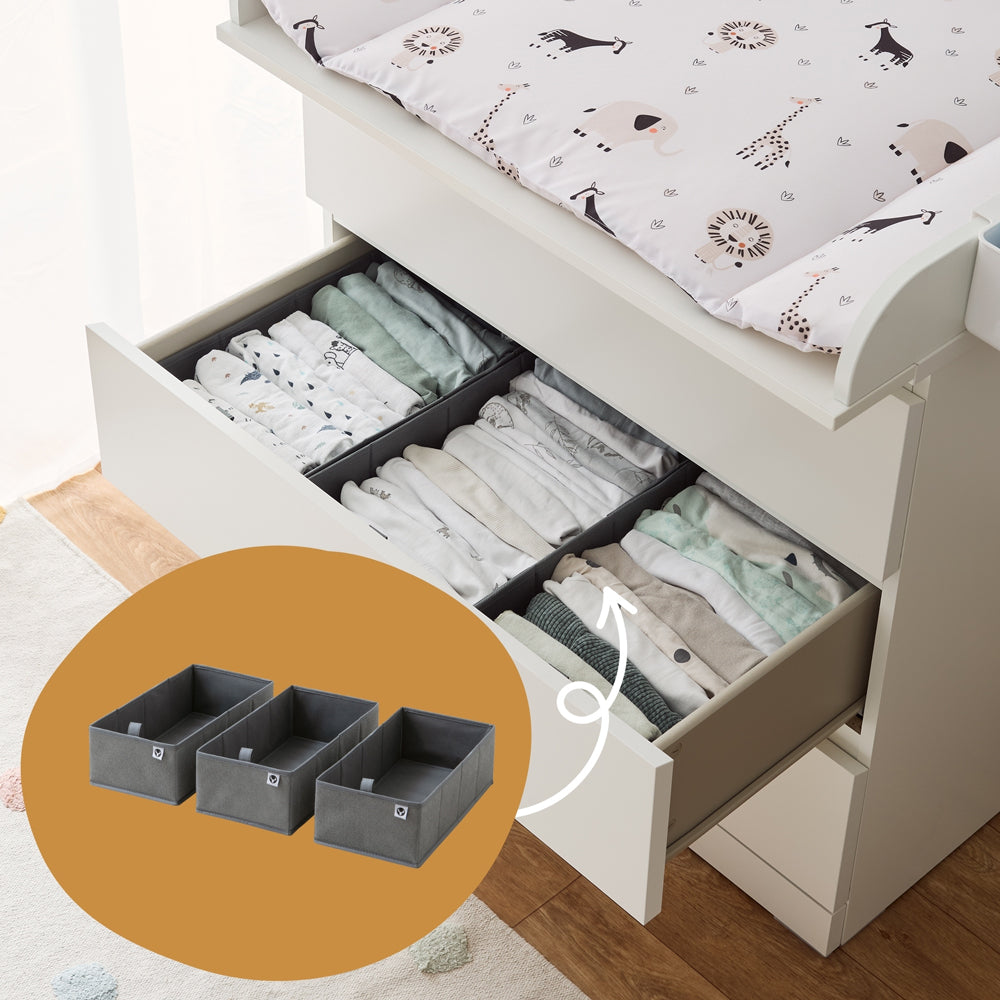IKEA Malm Wickelkommode mit 3 einsetzbaren Faltboxen, in die gefaltete Babykleidung einsortiert ist.