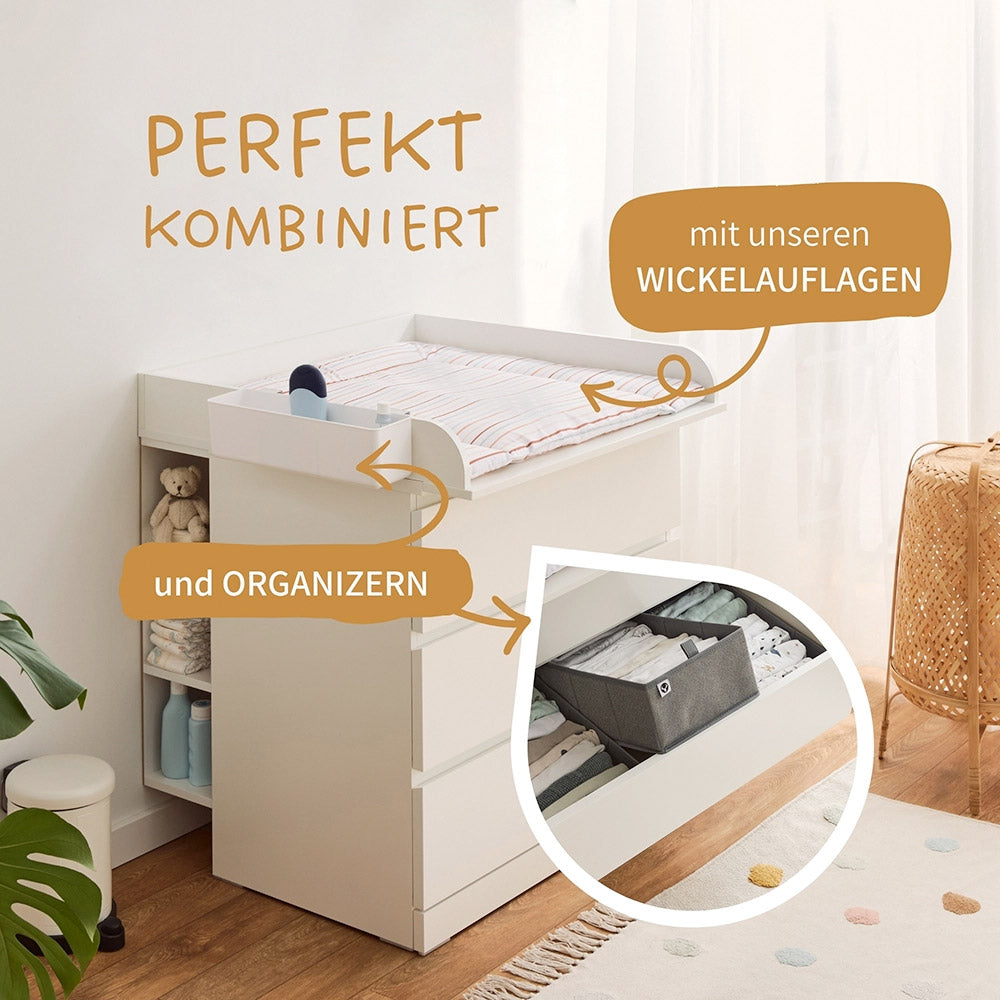 Eingerichteter Wickeltisch, bestehend aus einer IKEA Malm Kommode, Wickelauflage, Stauraumregal und passenden Organizern.