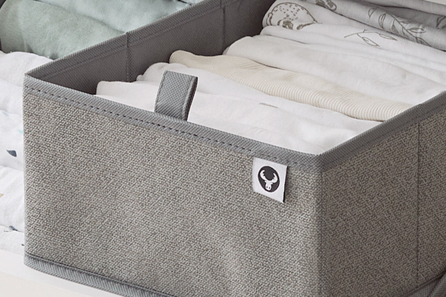 Grauer Schubladen Organizer mit Babykleidung.