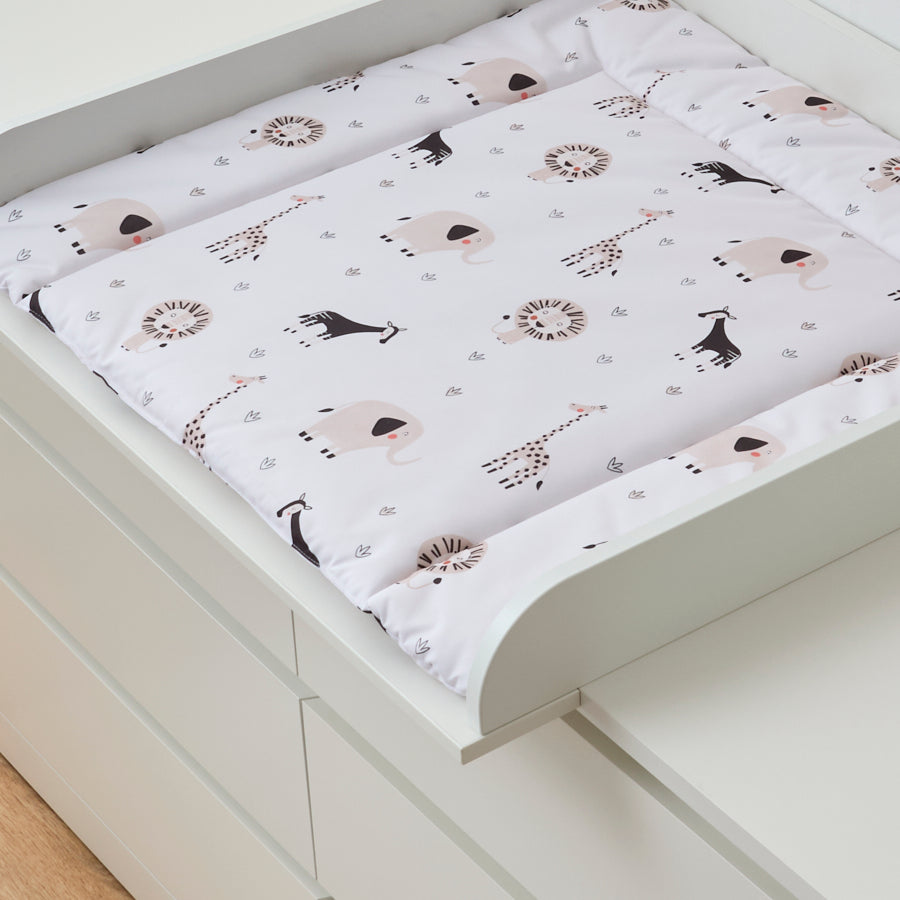 Eine mit afrikanischen Tieren bedruckte Wickelauflage, die in einem weißen Wickelaufsatz liegt, die auf einer farblich gleichen Malm Kommode von IKEA montiert ist.
