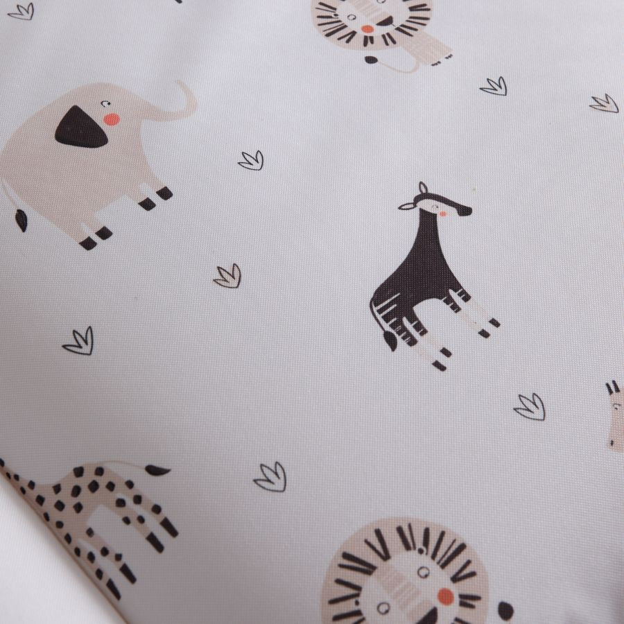 Nahaufnahe einer weißen Wickelauflage mit Tiermotiven aus Afrika. Zu sehen sind stilistische Motive von Elefant, Löwe und Giraffe