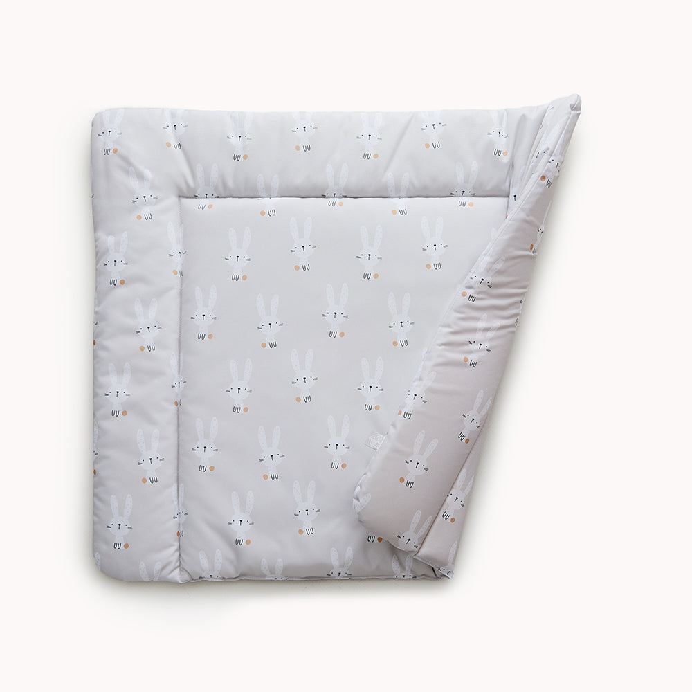 Abwaschbare Wickelauflage aus Folie mit Hasen-Print. Eine Ecke der Auflage ist schräg umgeklappt, so dass sich der beidseitige Druck erkennen lässt.