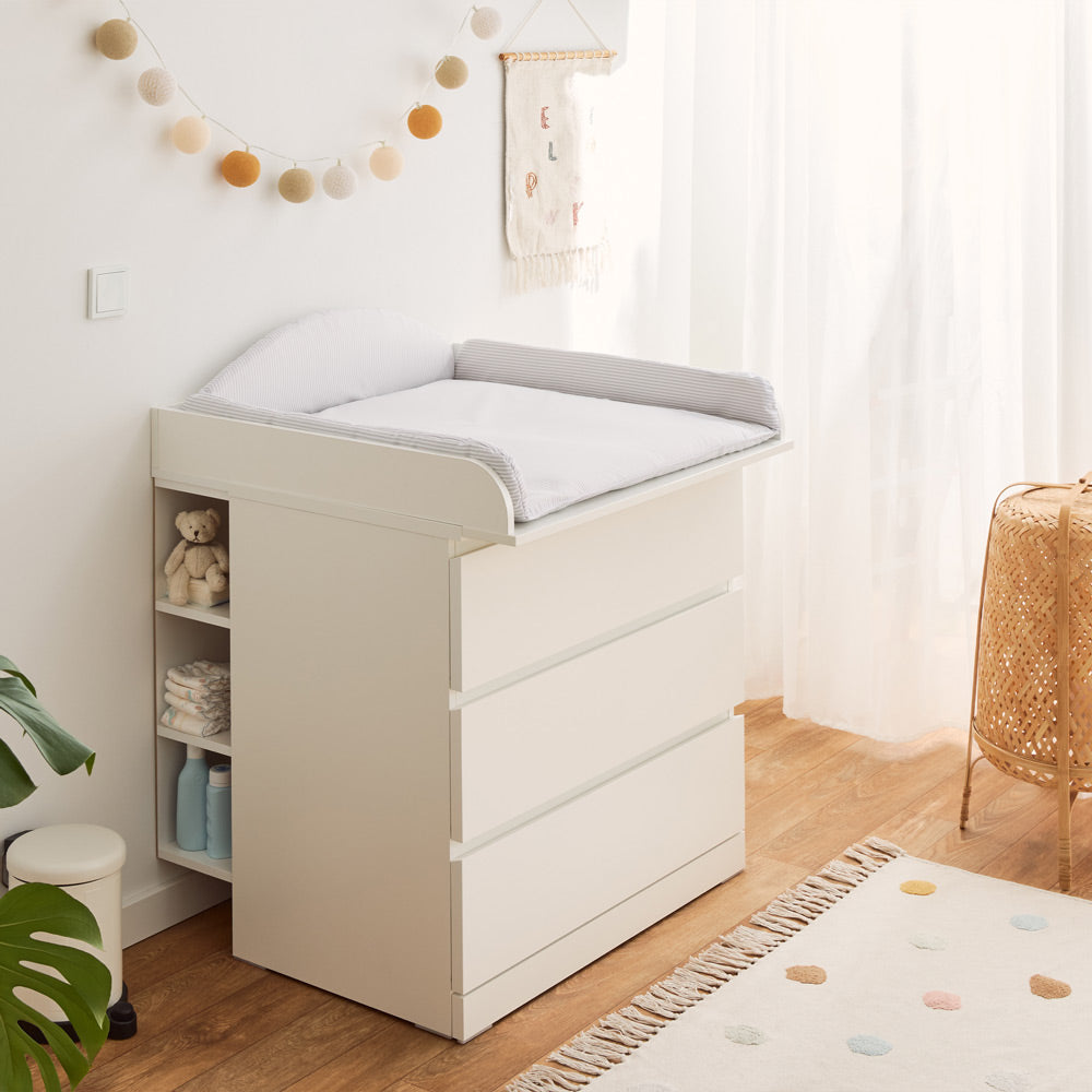 Malm Wickelkommode mit Wickelaufsatz und Wickelauflage mit flexibler Umrandung in Streifenmuster.