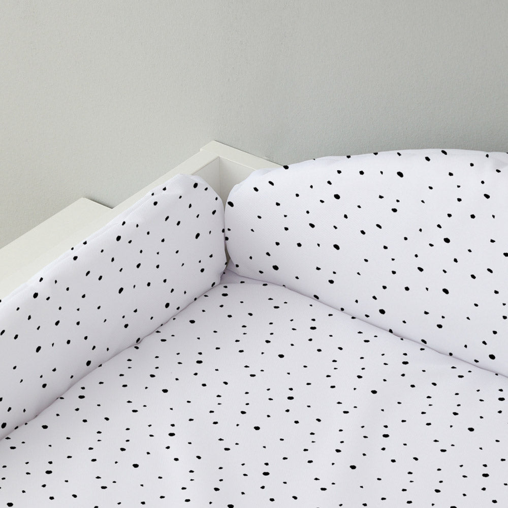 Auf einem Wickelaufsatz liegt eine Wickelauflage mit Umrandung im Punkte-Muster.