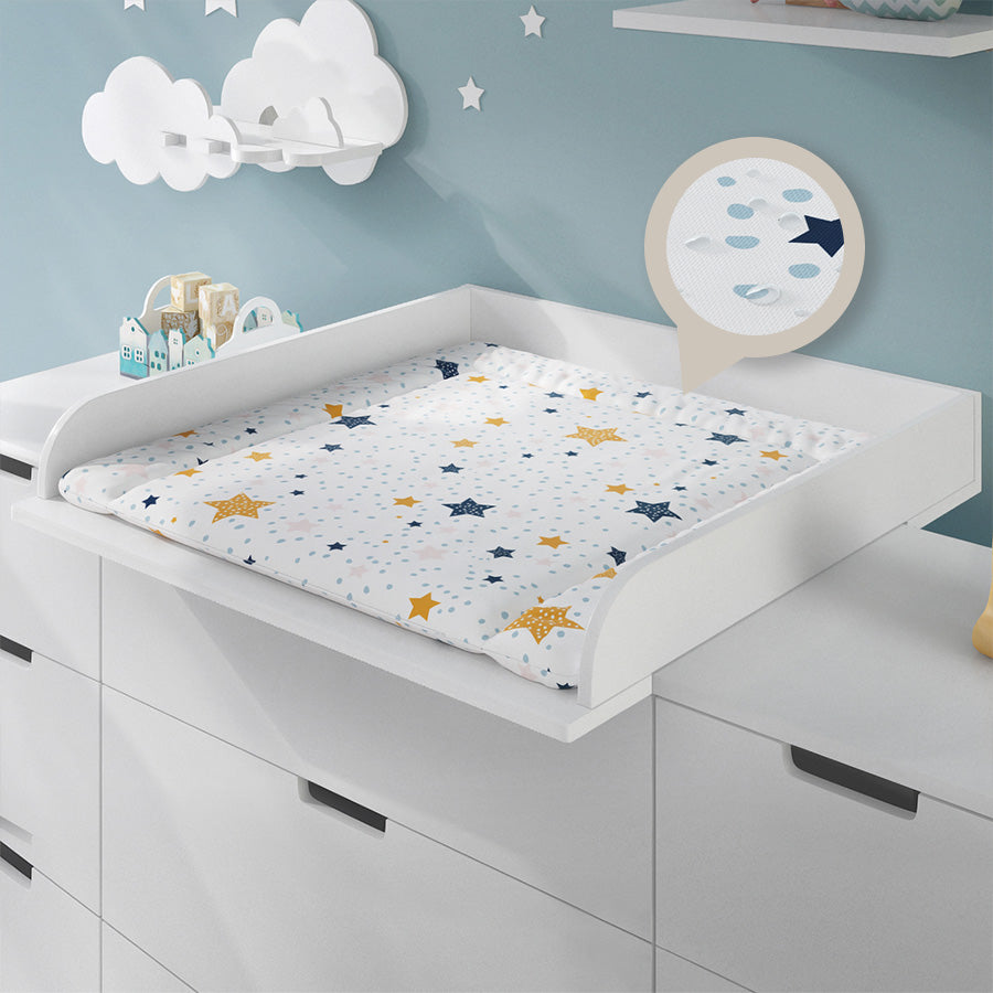 Wickelauflage weiß mit orangen und dunkelblauen Sternen in einem passenden Wickelaufsatz auf einer Wickelkommode