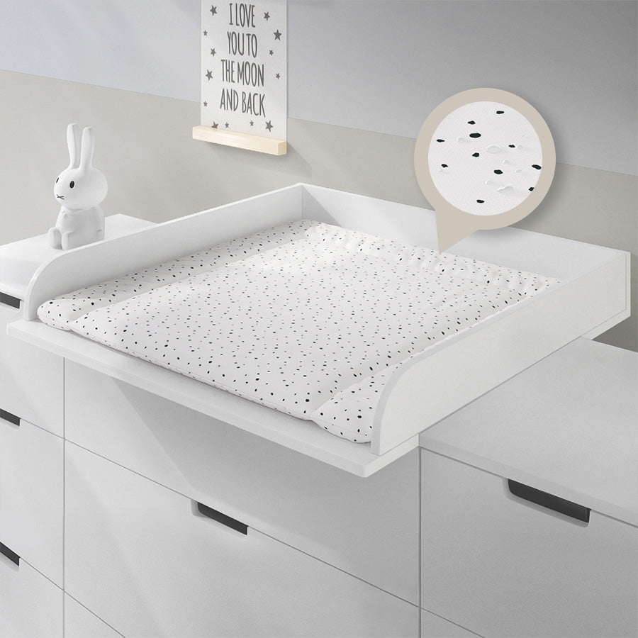 Weisse Wickelauflage mit kleinen schwarzen Punkten in einem 80 cm breiten Wickelaufsatz, der auf einer Kommode von Ikea montiert ist