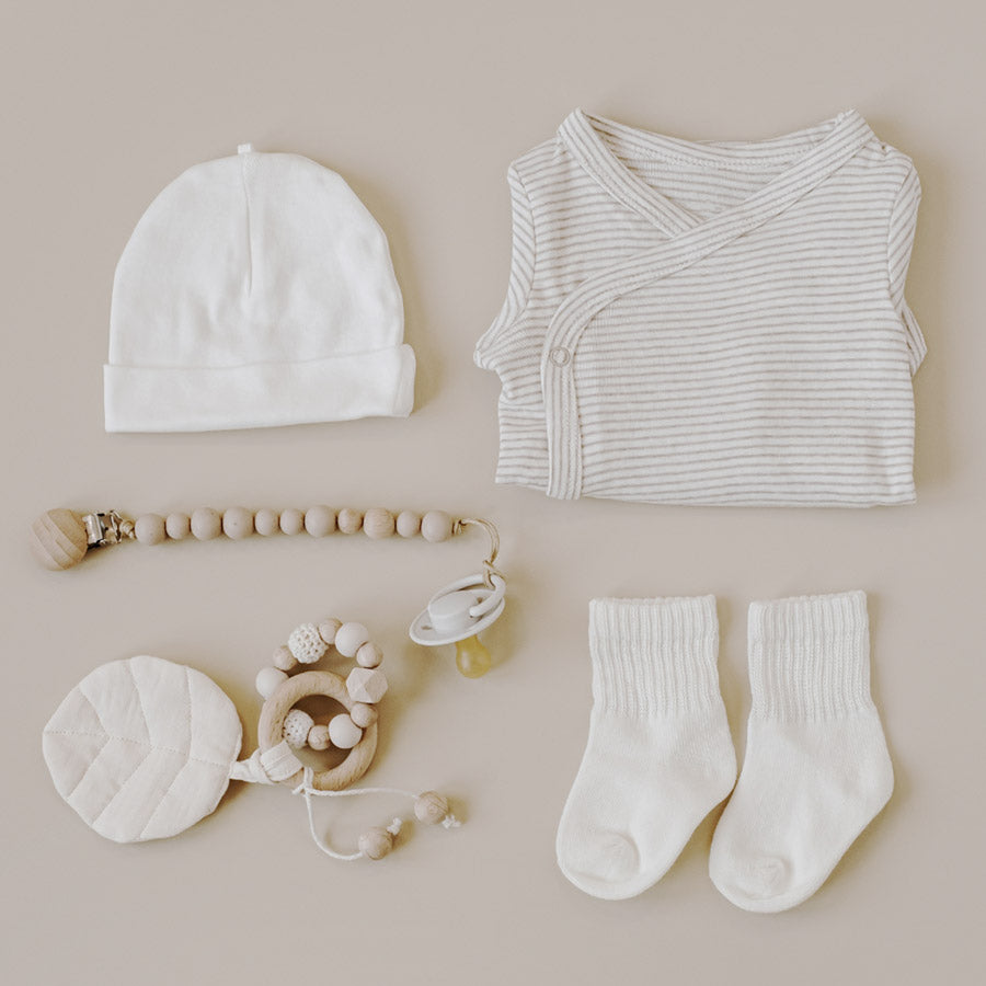 Babykleidung und Zubehör in Cremeweiß.