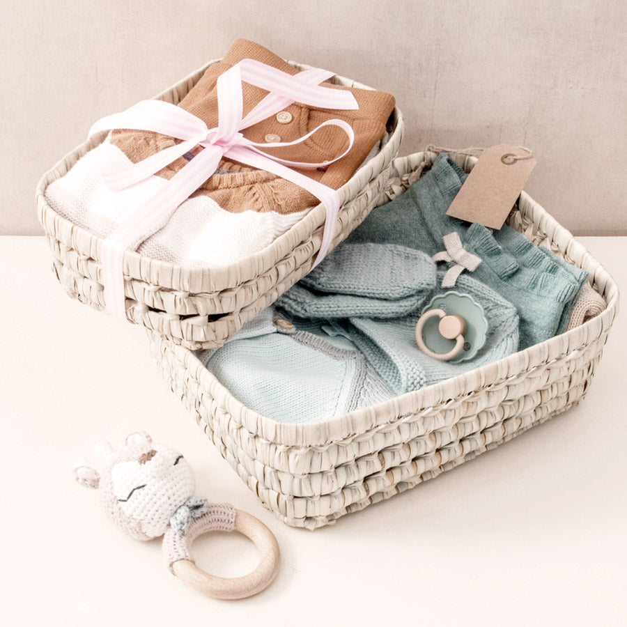 2 gefüllte Körbchen mit Babykleidung.