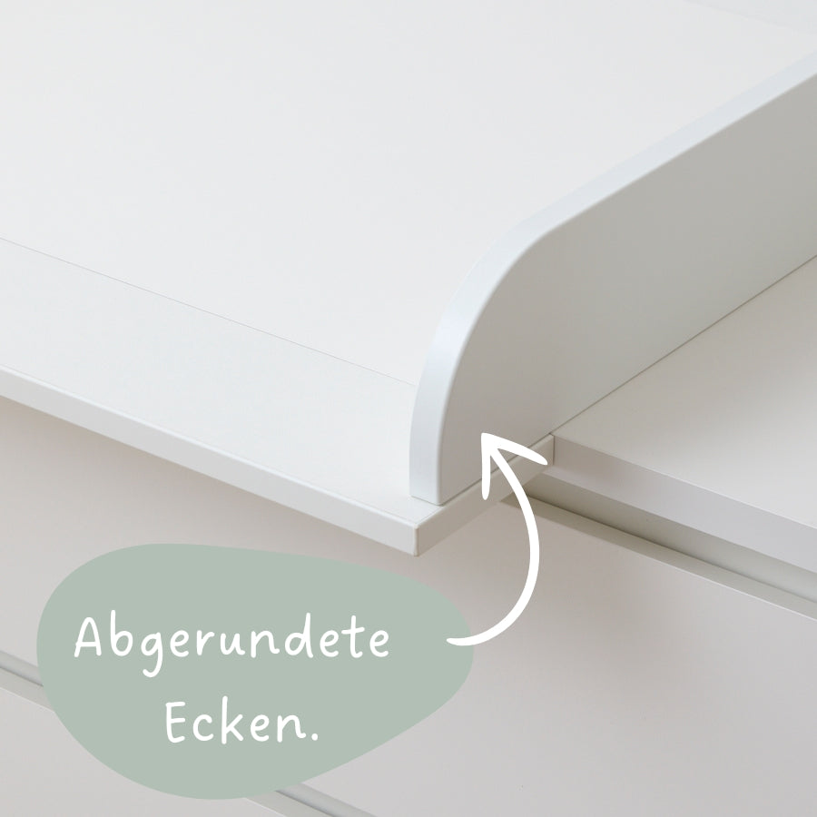 Weiße IKEA Malm Kommode mit einem weißen Wickelaufsatz, mit abgerundeten Ecken.