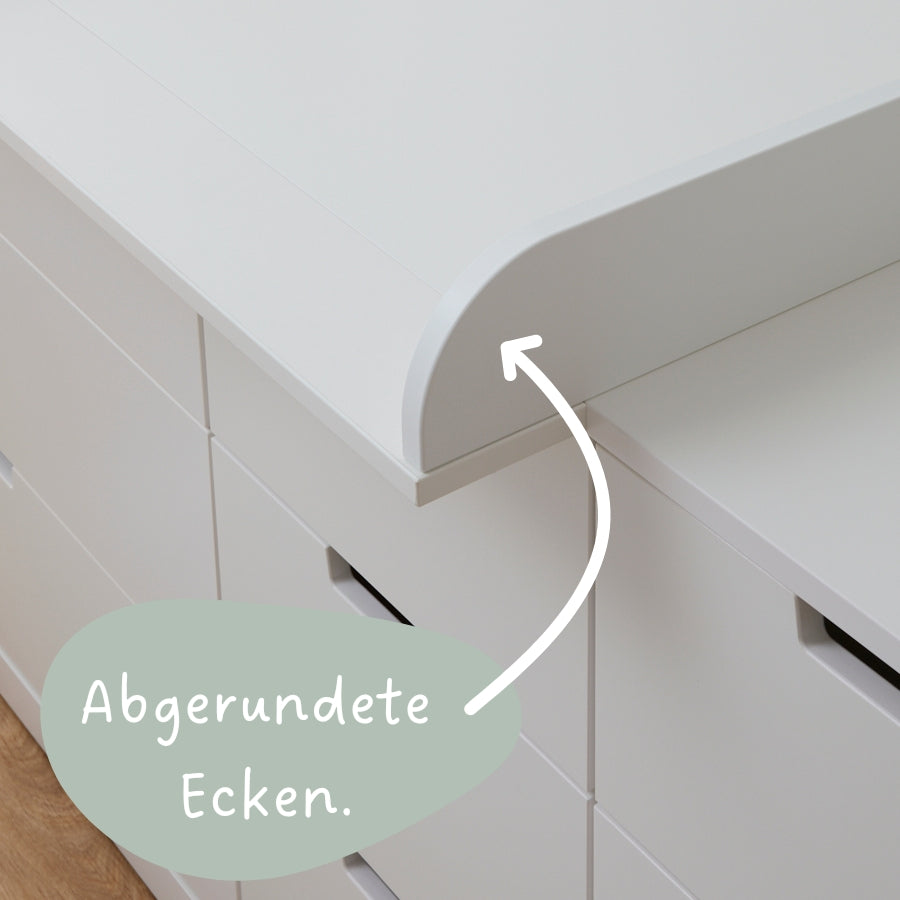 Weiße IKEA Nordli Kommode mit einem weißen Wickelaufsatz, mit abgerundeten Ecken.