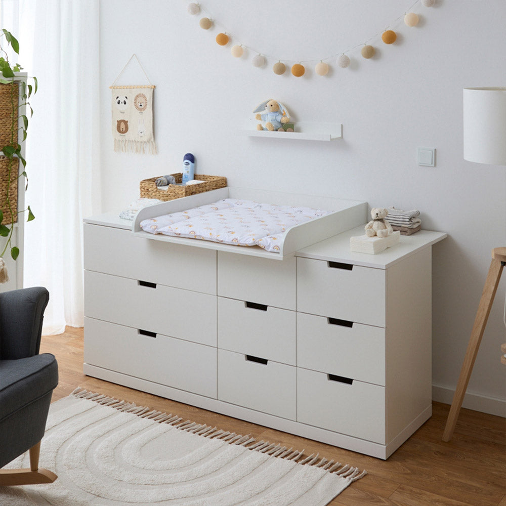 Eingerichteter Wickelplatz, der aus einer großen Nordli Kommode von IKEA besteht. Auf der Kommode liegt ein passgenauer Wickelaufsatz samt Wickelauflage.