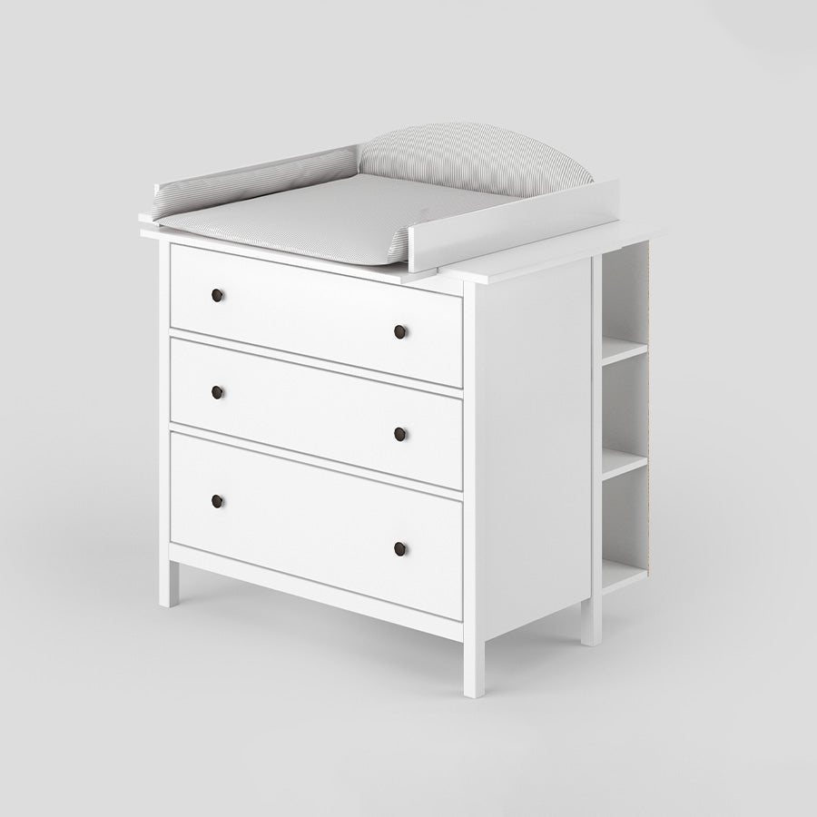 Weiße Hemnes Kommode von IKEA mit passgenauem Wickelaufsatz, einem Stauraumregal und Wickelauflage mit grauen Streifen.